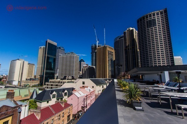 O que fazer em Sydney: The Rocks visto de cima, com suas casinhas coloridas e prédios do centro gigantescos atrás