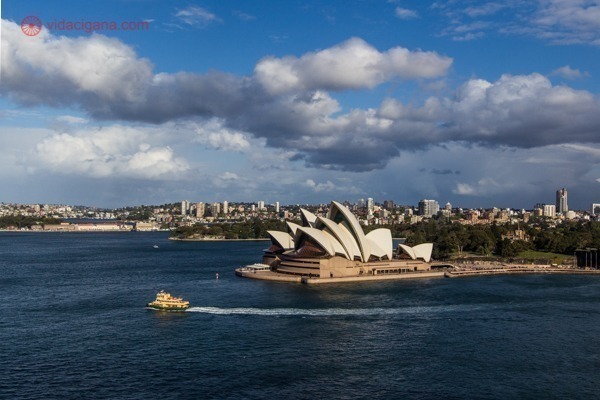 O que fazer em Sydney: a Ópera de Sydney vista da ponte, com uma balsa passando na frente do edifício