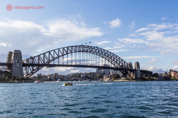 O que fazer em Sydney: A Harbour Bridge, a ponte mais famosa da Austrália, por cima do mar, com o céu azul