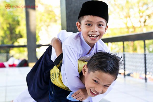 Dois meninos brincam no interior da mesquita nacional da Malásia em Kuala Lumpur