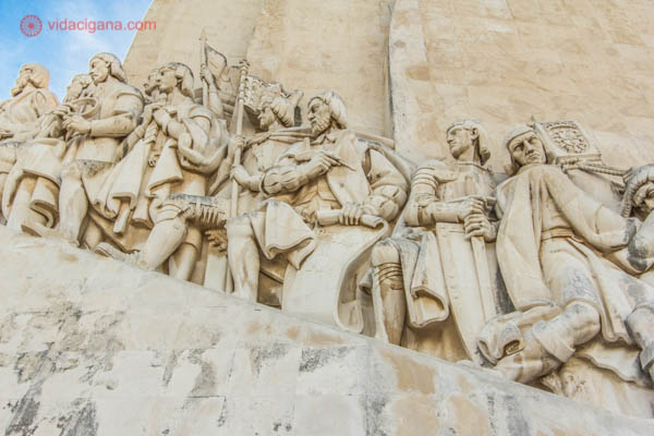 Detalhe do Padrão dos Descobrimentos em Lisboa, com vários navegadores representados na pedra. O céu está azul ao fundo.