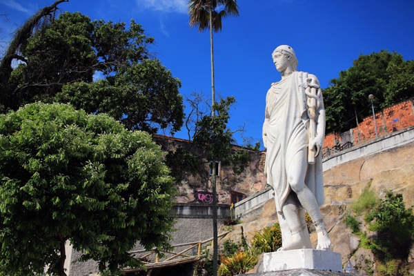Estátuas em estilo grego dos Jardins Suspensos, no Rio de Janeiro. Cercado de verde e árvores, o céu é azul.