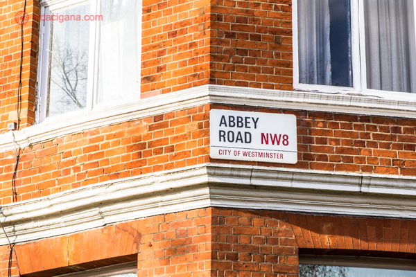 Abbey Road em Londres: A placa de uma das ruas mais famosas da Inglaterra, em um prédio de esquina de tijolinhos laranjas.