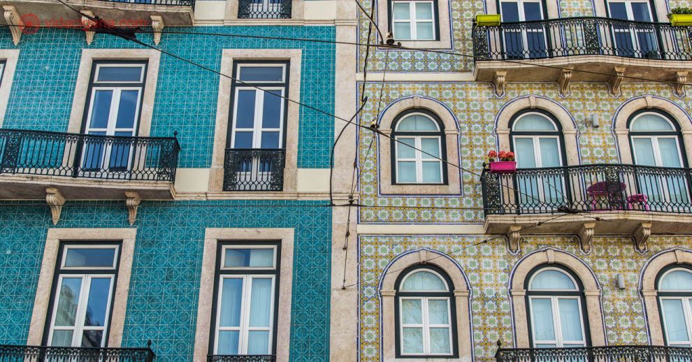 Onde ficar em Lisboa: Os famosos sobrados em Lisboa, com suas fachadas feitas em azulejos. Na foto são dois prédios, um dos lado do outro, com azulejos diferentes. Várias janelas dão para a rua, com sacadas. É uma arquitetura bem agradável e bonita.