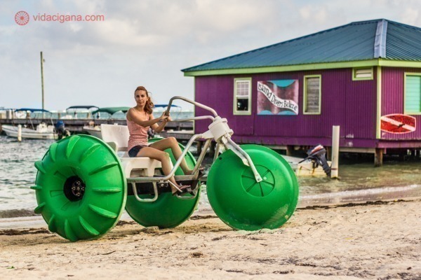 O que fazer em Belize: Que tal andar em uma bicicleta híbrida em San Pedro, a cidade mais famosa de Belize? A bicicleta anda sobre o mar do Caribe, sendo uma ótima forma de poder ver toda aquela diversidade de vida nas águas transparentes do país. Na foto eu estou posando em uma parada na praia.
