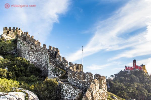 As muralhas do Castelo dos Mouros a frente e o Palácio de Pena ao fundo, com suas paredes coloridas. Duas das atrações mais visitadas de Sintra.