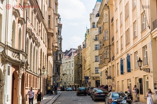 Onde ficar em Praga: O Bairro Judeu, com suas ruas estreitas cheias de prédios de 5 andares em tons pasteis, vários carros parados em sua calçada.