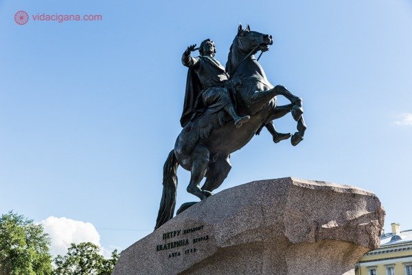 O que fazer em São Petersburgo: O Cavaleiro de Bronze, a estátua equestre de Pedro, o Grande, em cima da Pedra do Trovão. O céu está azul.