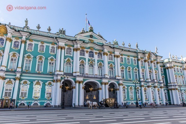 O que fazer em São Petersburgo: A entrada do Museu Hermitage, o Antigo Palácio de Inverno dos czares, com suas paredes verde-água, uma ampla colunata branca e detalhes dourados.