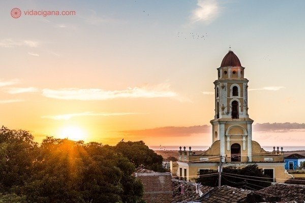 Principais pontos turísticos de Cuba: Um pôr do sol visto do topo da cidade de Trinidad, em Cuba, com sua igreja em primeiro plano. Lindíssimo.
