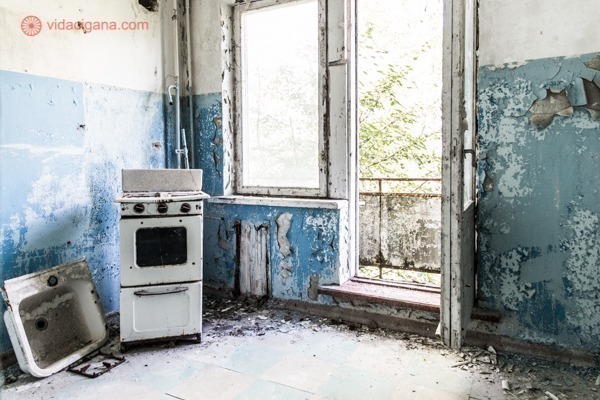 Como visitar Chernobyl: A cozinha de um apartamento em Chernobyl, com suas paredes azuis, fogão e pia, com uma varanda