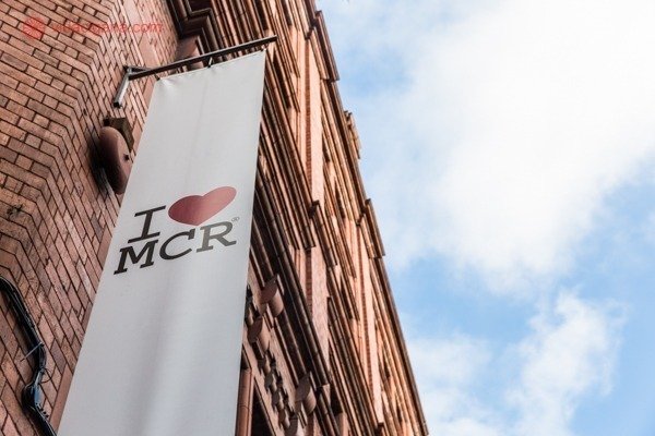 Faixa com logotipo "Eu amo Manchester" colocada na fachada de um dos prédios da cidade