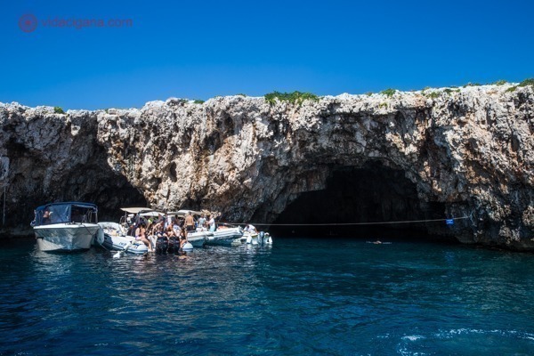 Passeio de barco em Hvar: A entrada da caverna verde, com algumas lanchas paradas em frente a ela.