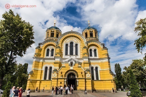O que fazer em Kiev: A Catedral de São Vladimir, com suas paredes amarelas em contraste com o céu azul cheio de nuvens brancas