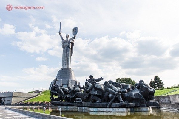 O que fazer em Kiev: O Monumento da Mãe Pátria a esquerda, com soldados soviéticos em primeiro plano na beira de uma fonte