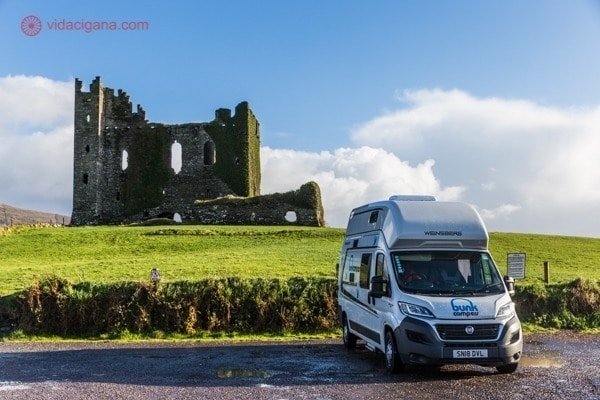 Roteiro Irlanda: Um motorhome parado na frente de uma ruína de um castelo na Irlanda