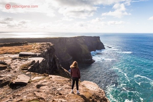 Roteiro Irlanda: uma mulher na beira do precipício em Kerry Cliffs, na Irlanda
