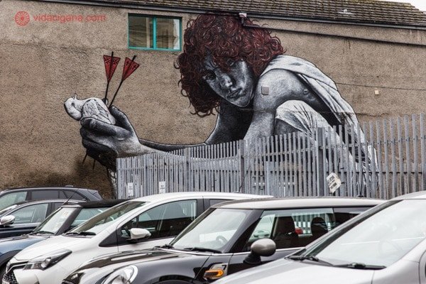 O que fazer em Belfast: uma arte de rua simbolizando a paz sendo morta pela religião