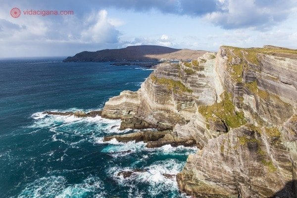 Aluguel de carro na Irlanda: O Kerry Cliffs ensolarado, com o mar ao seus pés de cor bem verde 