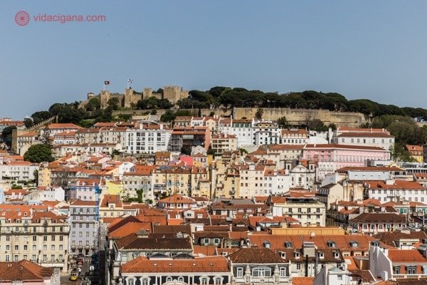 Lisboa vista do alto, com seus prédios todos coladinhos, coloridos e com o Castelo de São Jorge coroando a cidade