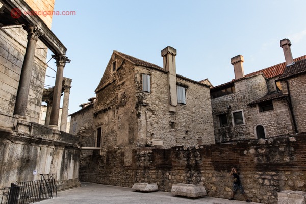 O que fazer em Split: casas de pedra com chaminés em meio a ruínas e um homem encostado na parede tirando uma foto