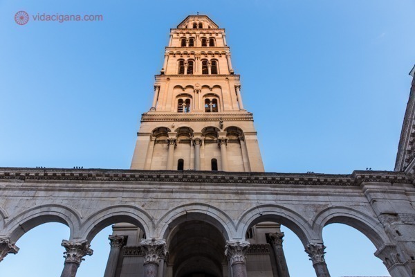 O que fazer em Split: a torre sineira da catedral de São Dômnio iluminada pelo sol, com seus arcos romanos na base