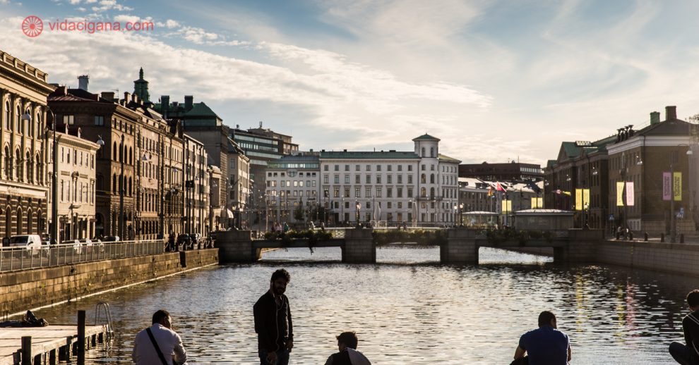 O que fazer em Gotemburgo: Pessoas sentadas nas margens do rio em Gotemburgo, na Suécia, com pontes e prédios baixos a frente