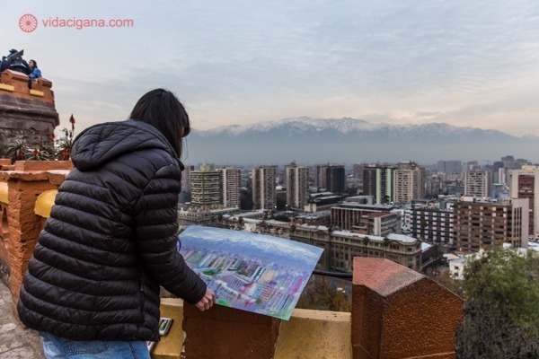 O que fazer em Santiago: o alto do Cerro Santa Lucía com um artista pintando a Cordilheira dos Andes que está no fundo da imagem