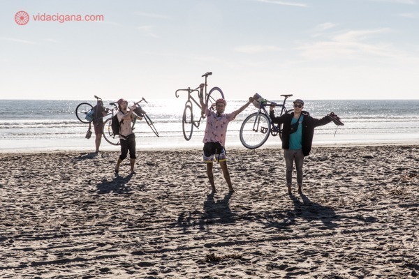 grupo de turistas carregando bicicletas na praia de La Serena