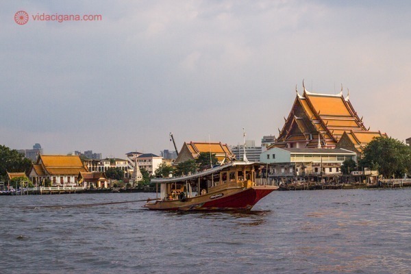 Onde ficar em Bangkok: um barco no rio Chao Phraya, em frente a templos