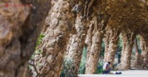 O que fazer em Barcelona: os corredores do Parc Guell feitos de pedra, com um homem tocando violão embaixo deles