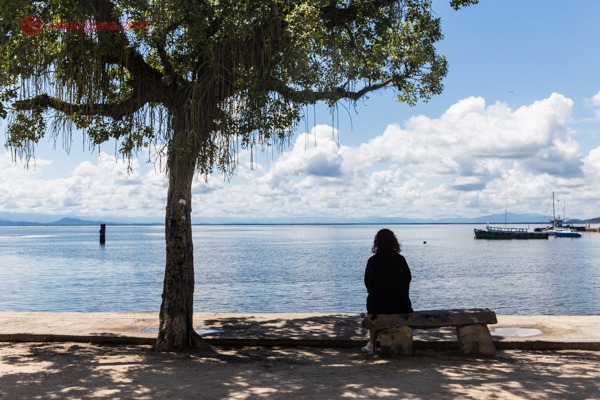 Uma mulher sentada em um banco na Praia José Bonifácio
