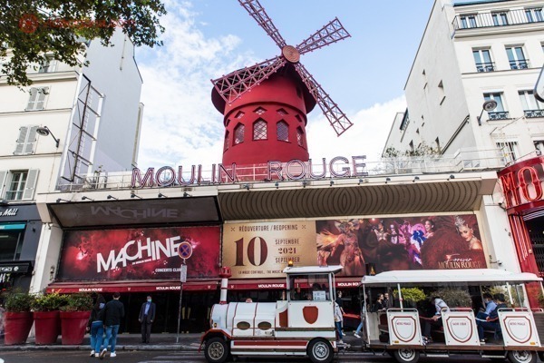 O moinho do Moulin Rouge, com um trenzinho passando em sua frente