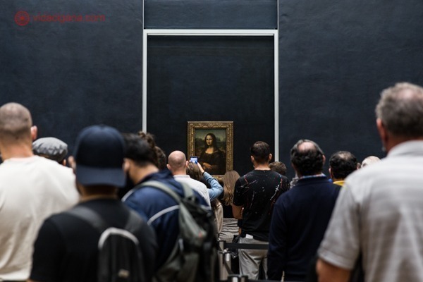 A Monalisa no Louvre, vista de longe com várias pessoas na fila