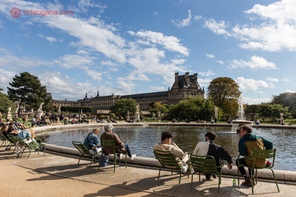 O 1° arrondissement em Paris, onde fica o Jardim de Tuileries, com várias pessoas sentadas na beira de uma fonte