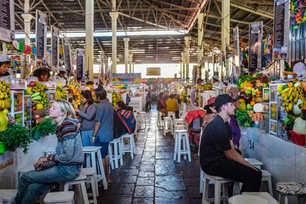 O interior do Mercado de San Pedro, cheio de turistas e barracas de comidas