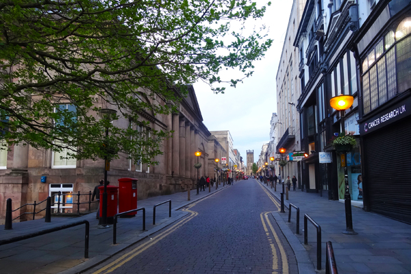 Uma rua com árvores e lojas ao entardecer no bairro Ropewalks em Liverpool