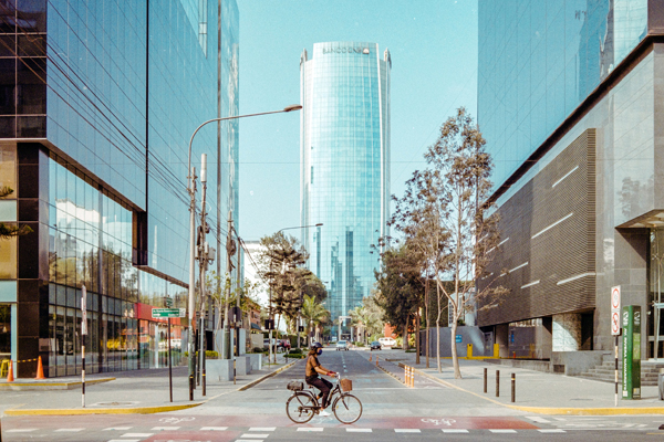O bairro de San Isidro, muito moderno, com prédios novos e uma pessoa andando de bicicleta na rodovia