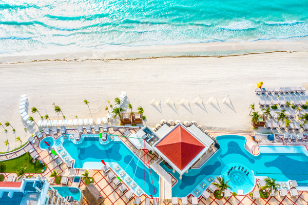 Onde ficar em Cancun: uma foto aérea de um resort na beira da praia, com mar e piscina lado a lado