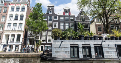 Onde ficar em Amsterdam: Uma casa barco em frente a lindos prédios da região de Jordaan