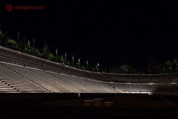 O Estádio Panatenaico de noite, com suas arquibancadas iluminadas e o pódio em frente