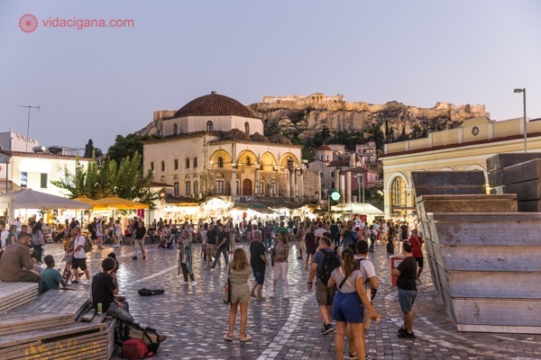 A Praça Monastiraki no fim da tarde, cheia de pessoas e com a Acrópole ao fundo