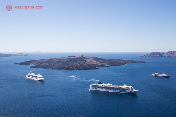 O que fazer em Santorini: o Mar Egeu com a ilha vulcânica no meio e vários cruzeiros ao redor