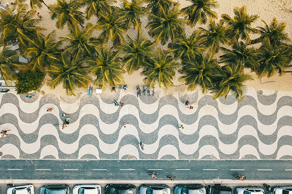 O calçadão de Copacabana visto de cima, com palmeiras ao redor