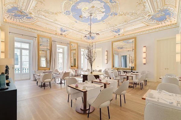 Hotéis de luxo em Lisboa: Um lindo refeitório com tetos brancos e azuis, janelas imensas e mesas brancas