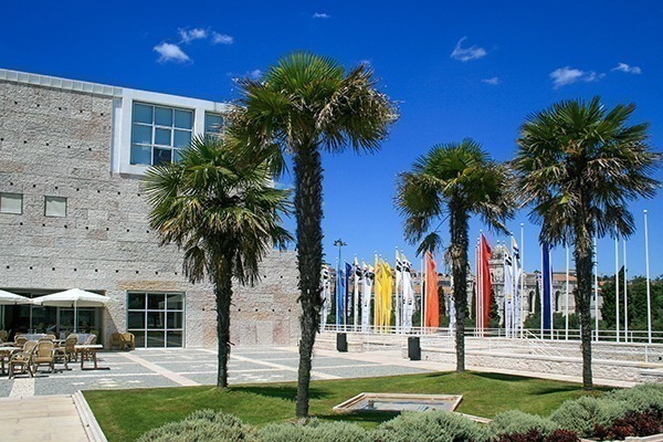 O Centro Cultural de Belem, com prédio claro, árvores e bandeiras