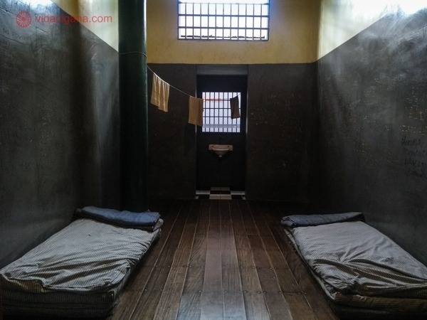 Uma das celas do Memorial da Resistência de São Paulo, com dois colchões no chão e uma pia ao centro. Um varal cruza o local