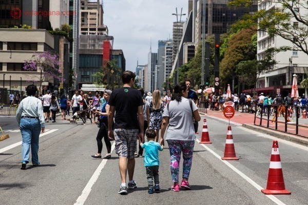 A Avenida Paulista aberta para pedestres aos domingos, cheia de pessoas caminhando e curtindo as várias atividades que acontecem por ali