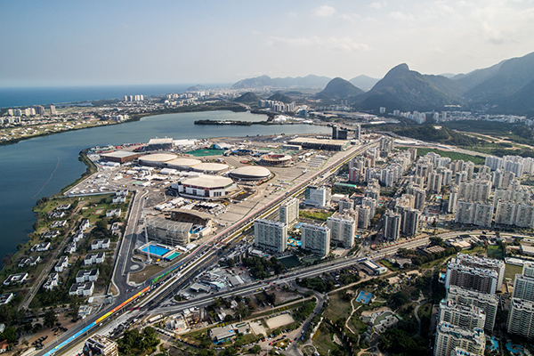 O Parque Olímpico visto de cima, com todas as instalações usadas nas Olimpíadas, vários prédios no entorno e montanhas