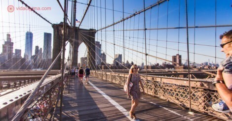 Onde ficar no Brooklyn: A Ponte do Brooklyn num dia ensolarado com uma mulher caminhando na ponte